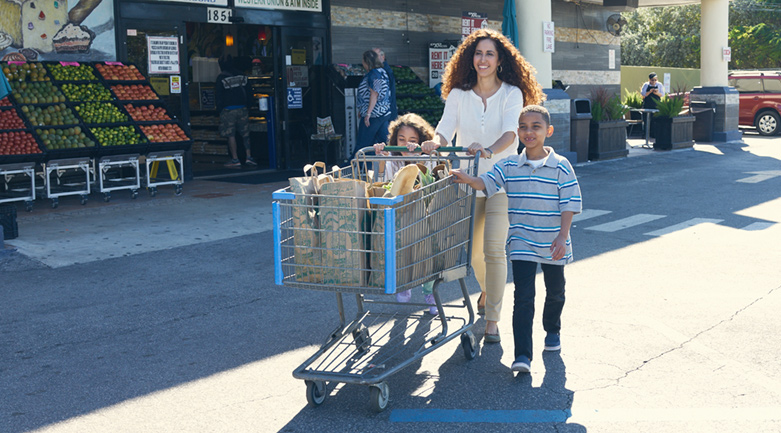 family pushing cart with groceries